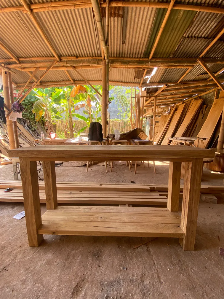 Meja makan kayu di bawah atap bengkel
